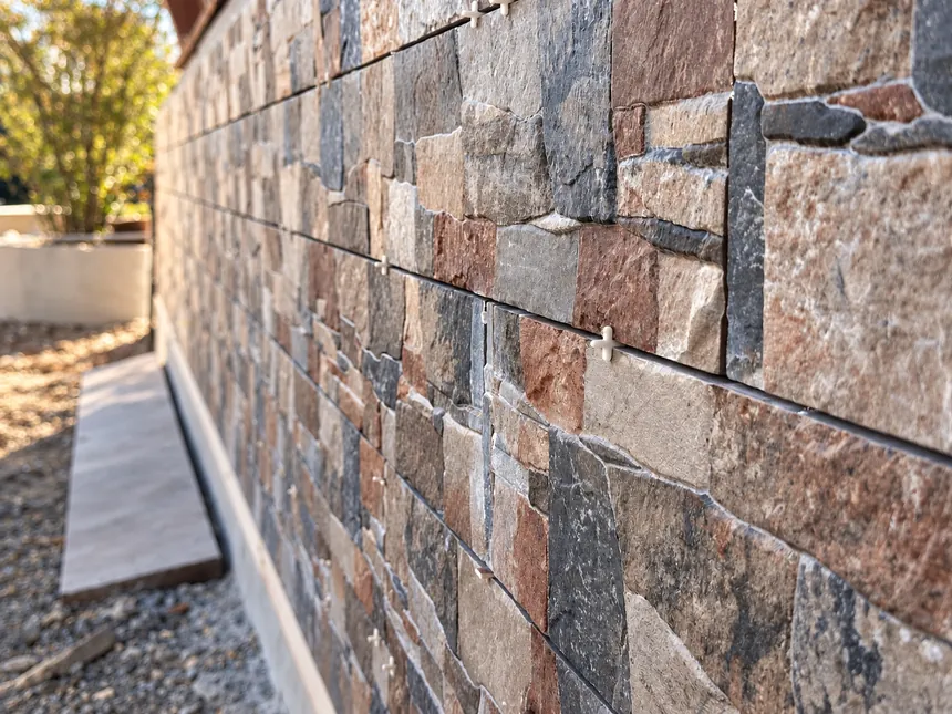 Stone veneer being fitted to an exterior wall